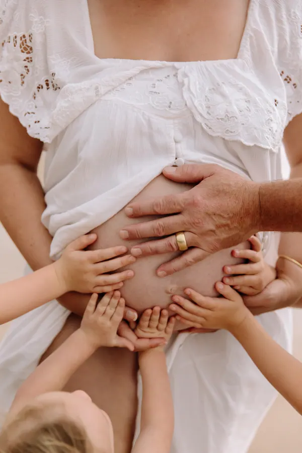 Small hands resting on Courtney's bump in her fourth pregnancy